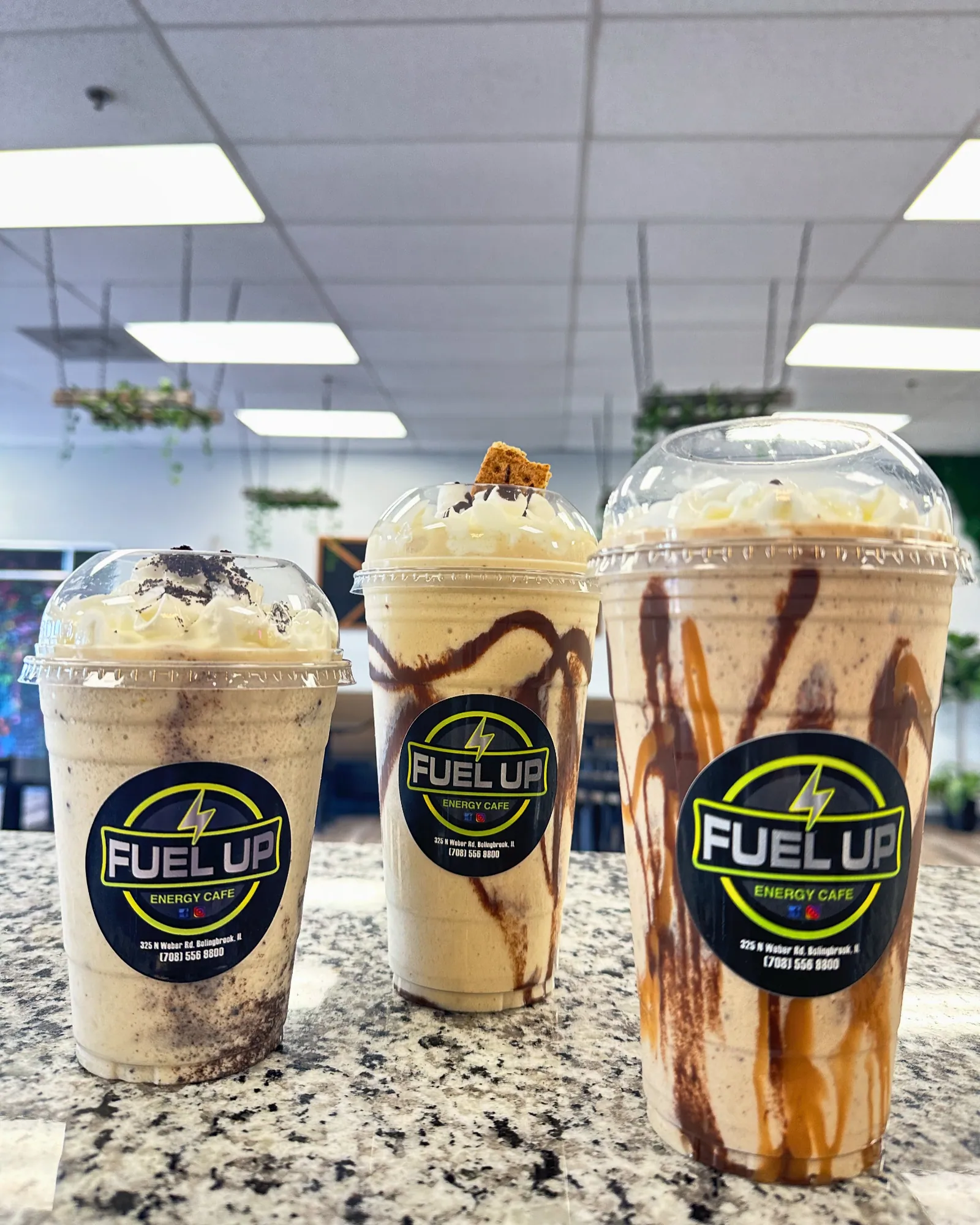 Three Fuel Up protein shakes with whipped toppings on the cafe counter
