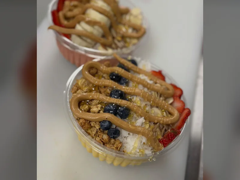 Granola, coconut, almonds, fresh fruit and drizzles on two bowls at Fuel Up Energy Cafe in Bolingbrook, IL